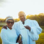 image of two people in white robes in front of a sunset